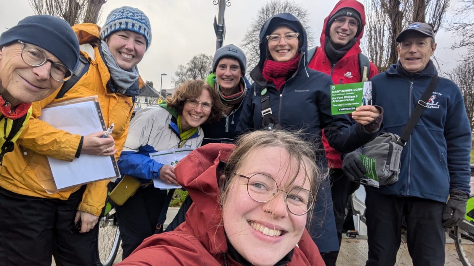8 smiling people holding Green Party leaflets